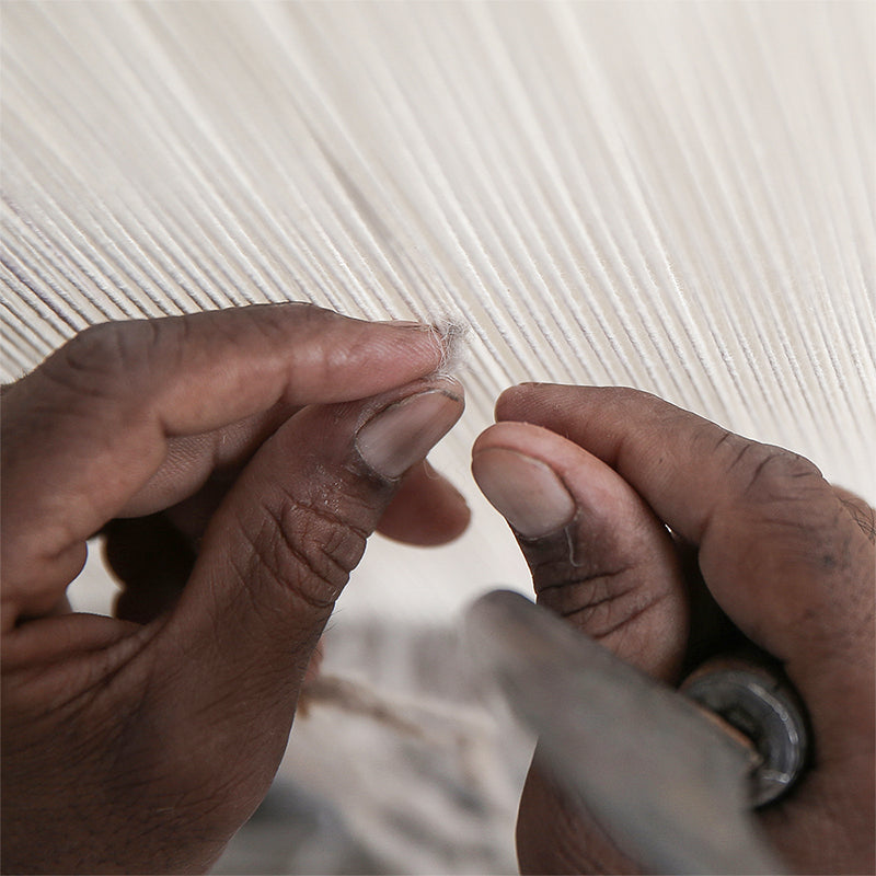Master artisan hand-knotting at the loom