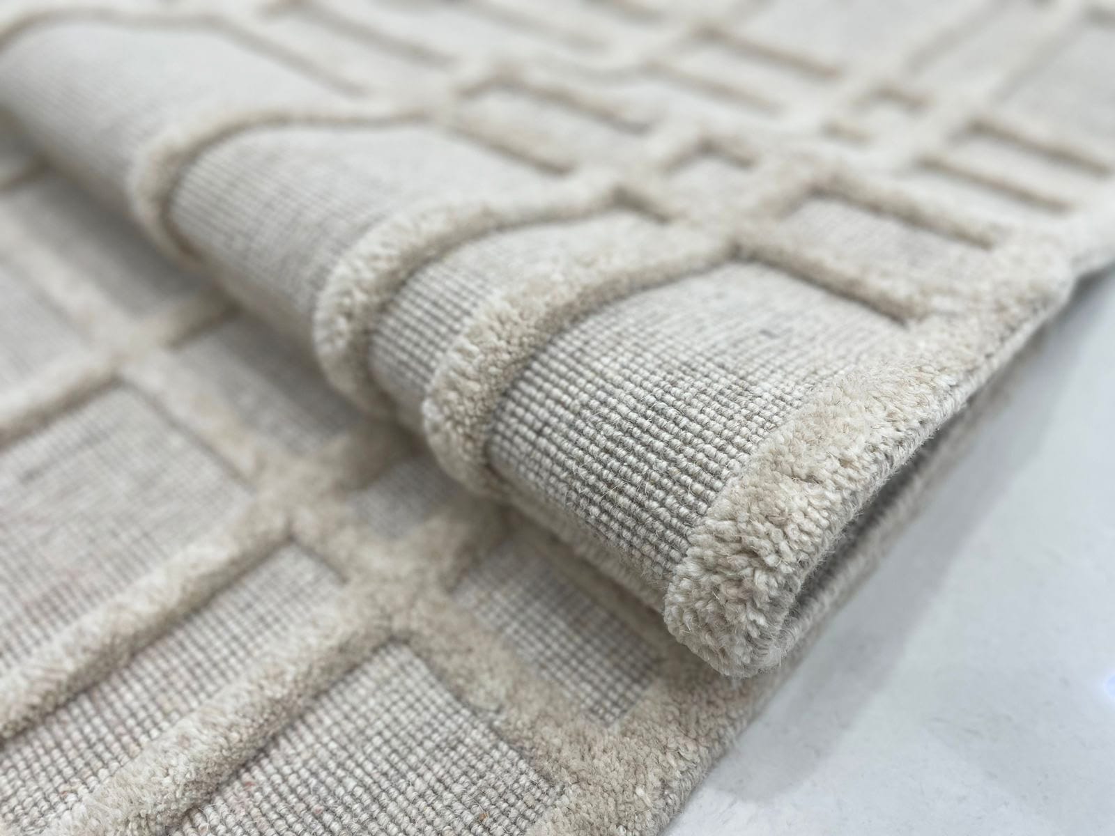 Hand-knotted rug detail — ivory grid pattern